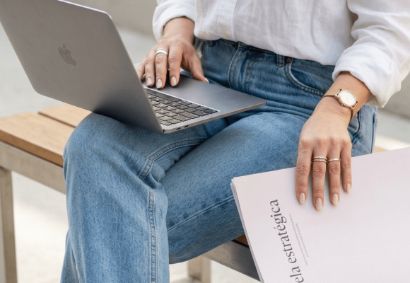 mulher com notebook apoiado no colo